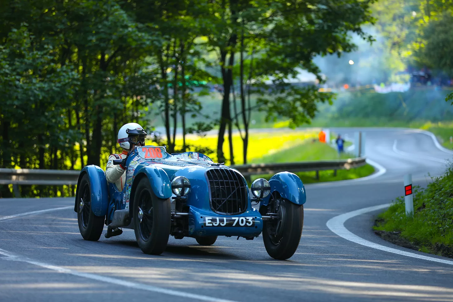 Old fashioned blue car with large wheels on track