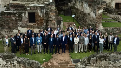 Group of people outside, standing amongst some ruins