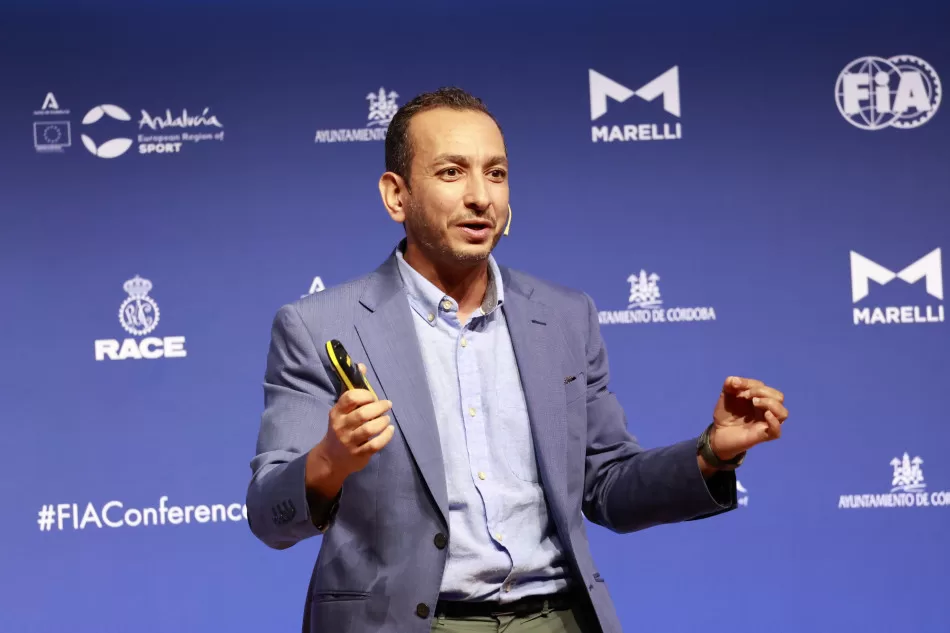 Man speaking in front of a blue background