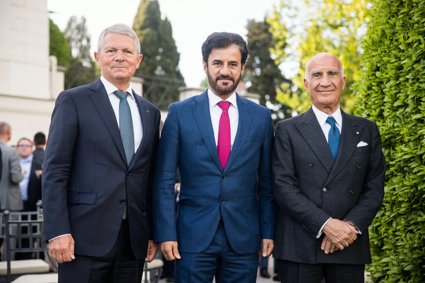 President in the center of a garden with a man on either side