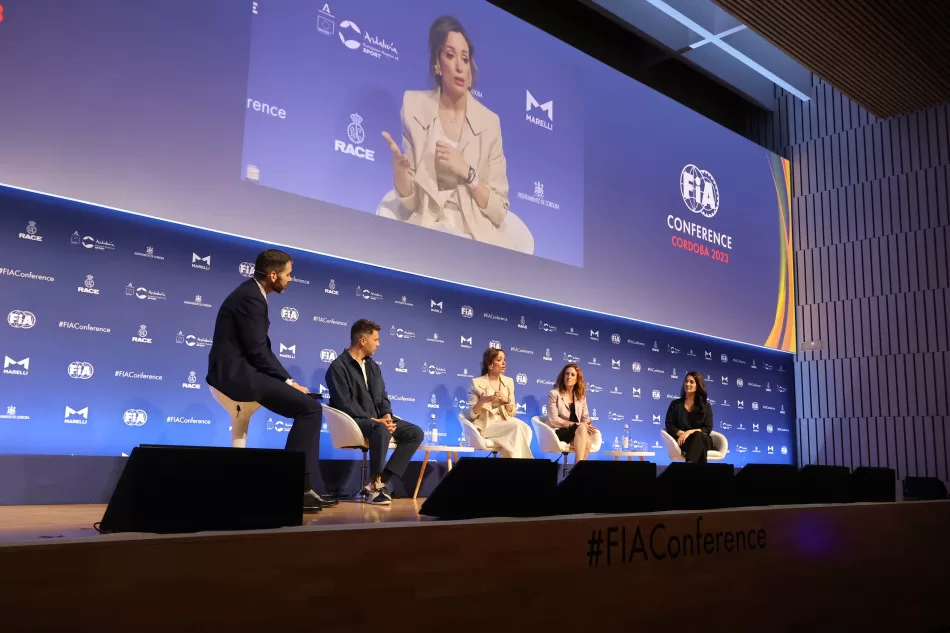 Panel of speakers with a large screen above them