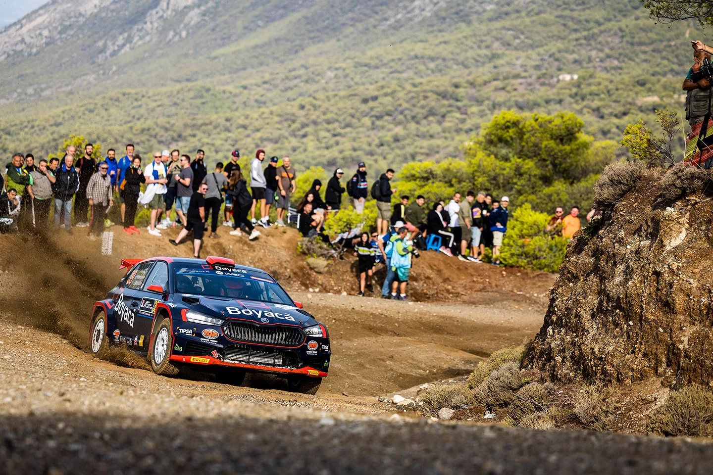 Car quickly going around the bend of a dirt track