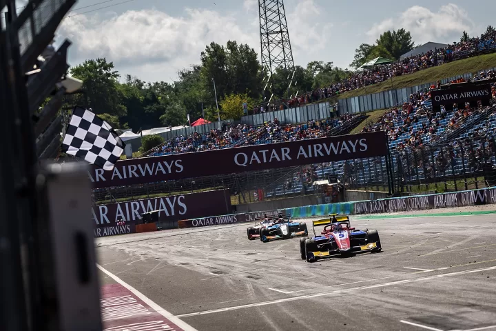 Two cars pass the checkered flag