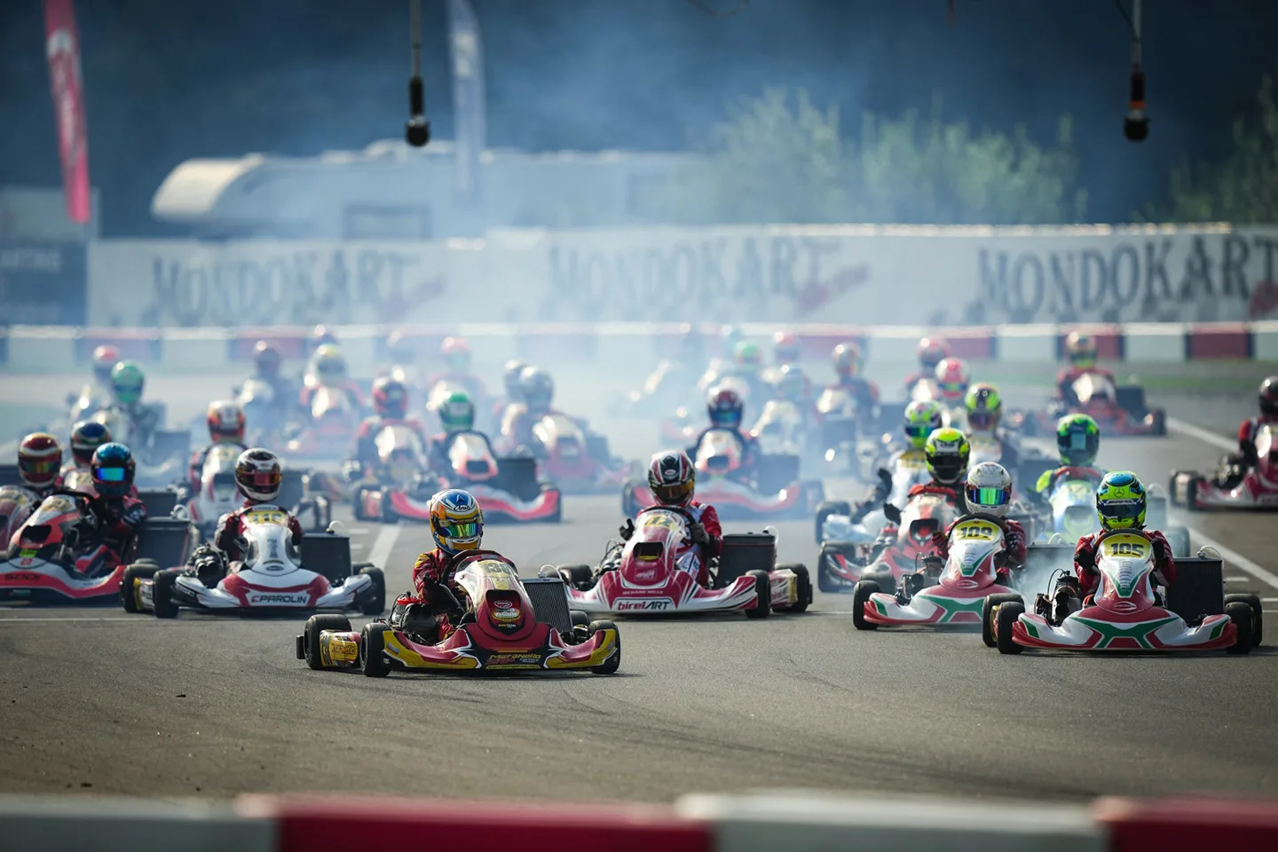 Karting drivers racing with smoke kicked up