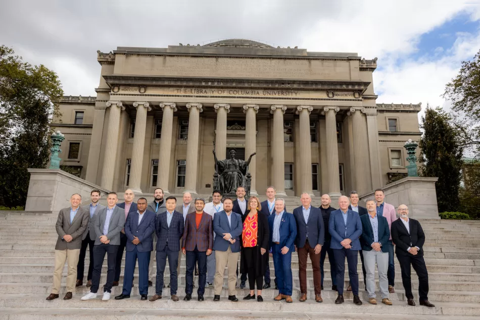 Group of people stood in front of a building with large columns