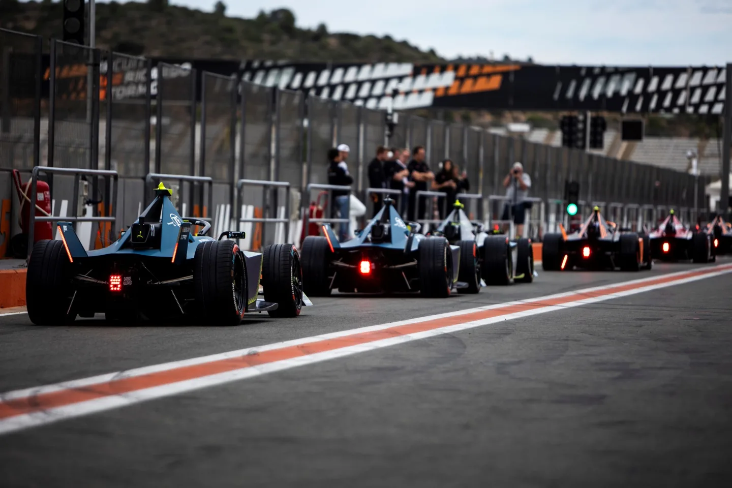 Racing cars line up on a grid